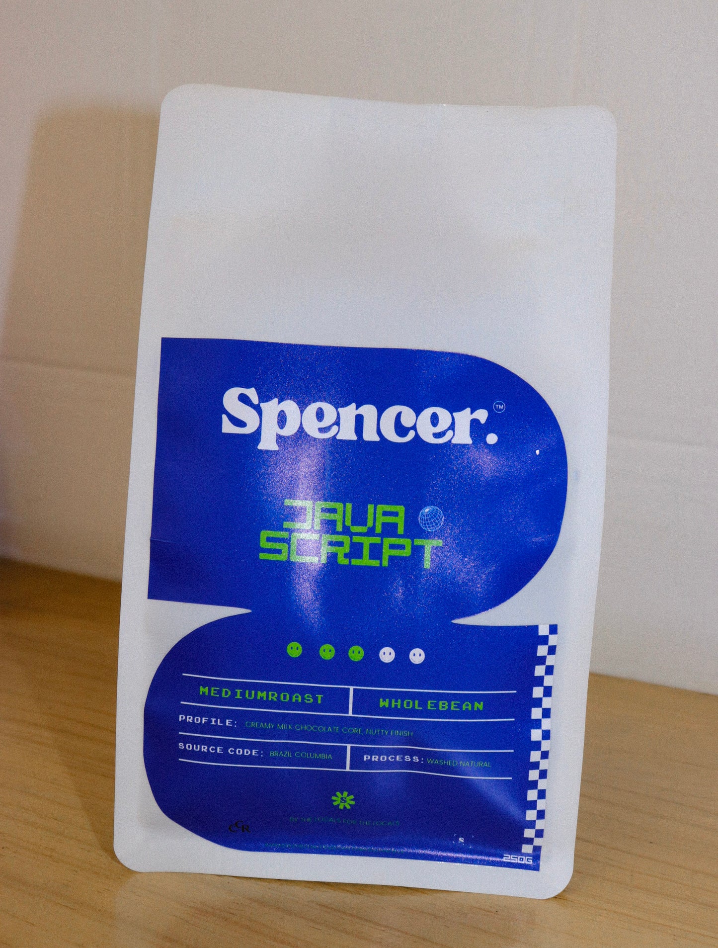 Spencer coffee package with blue and white design on a wooden surface